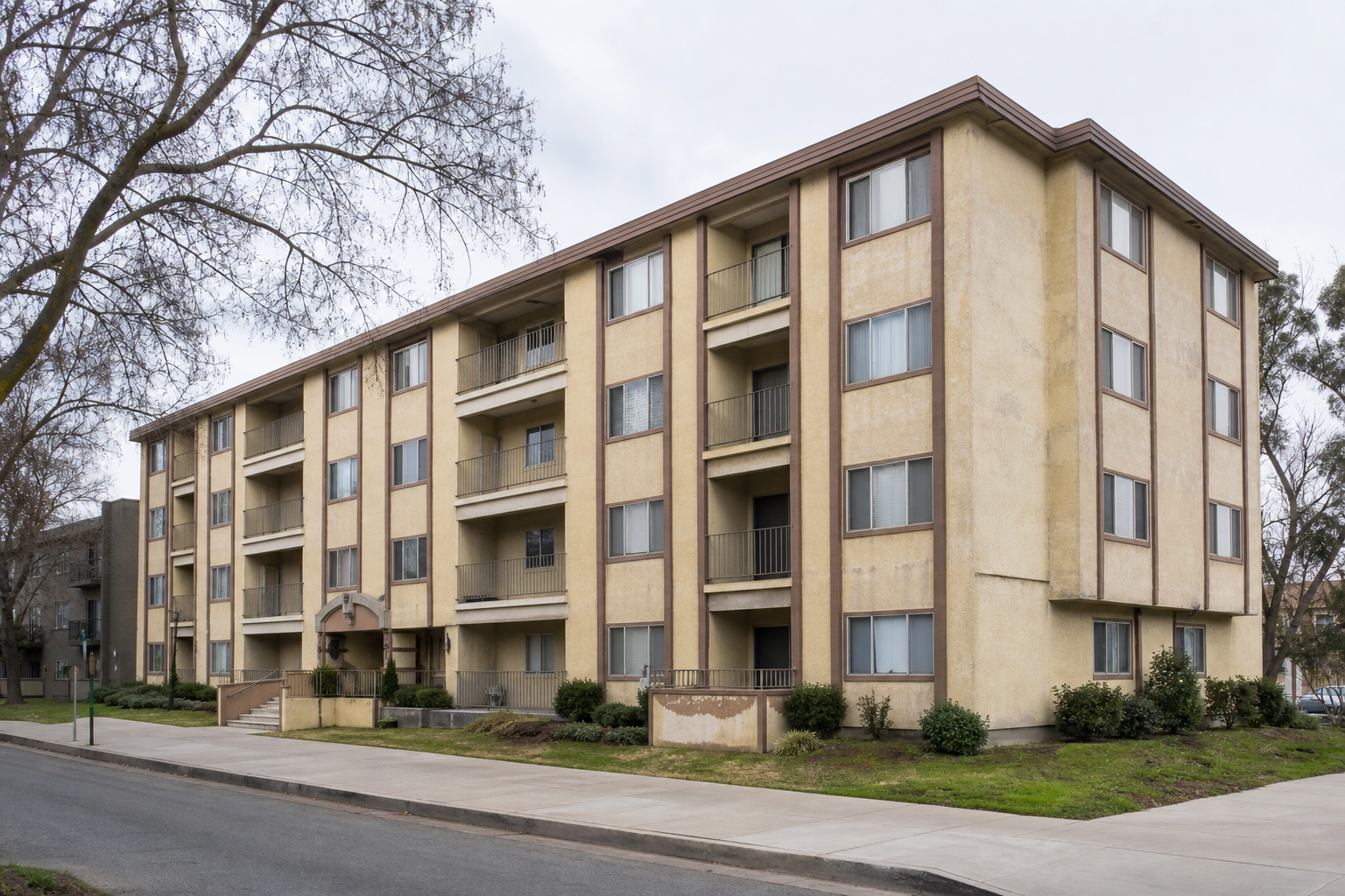 Representative apartment building with a weathered beige exterior before repainting